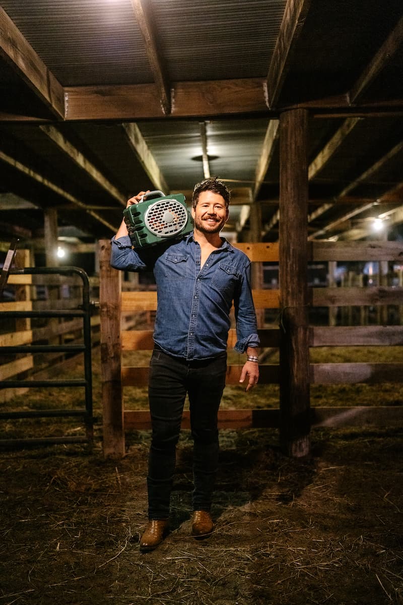 Shane Smith hanging his Turtlebox Original speaker in green color on his shoulder