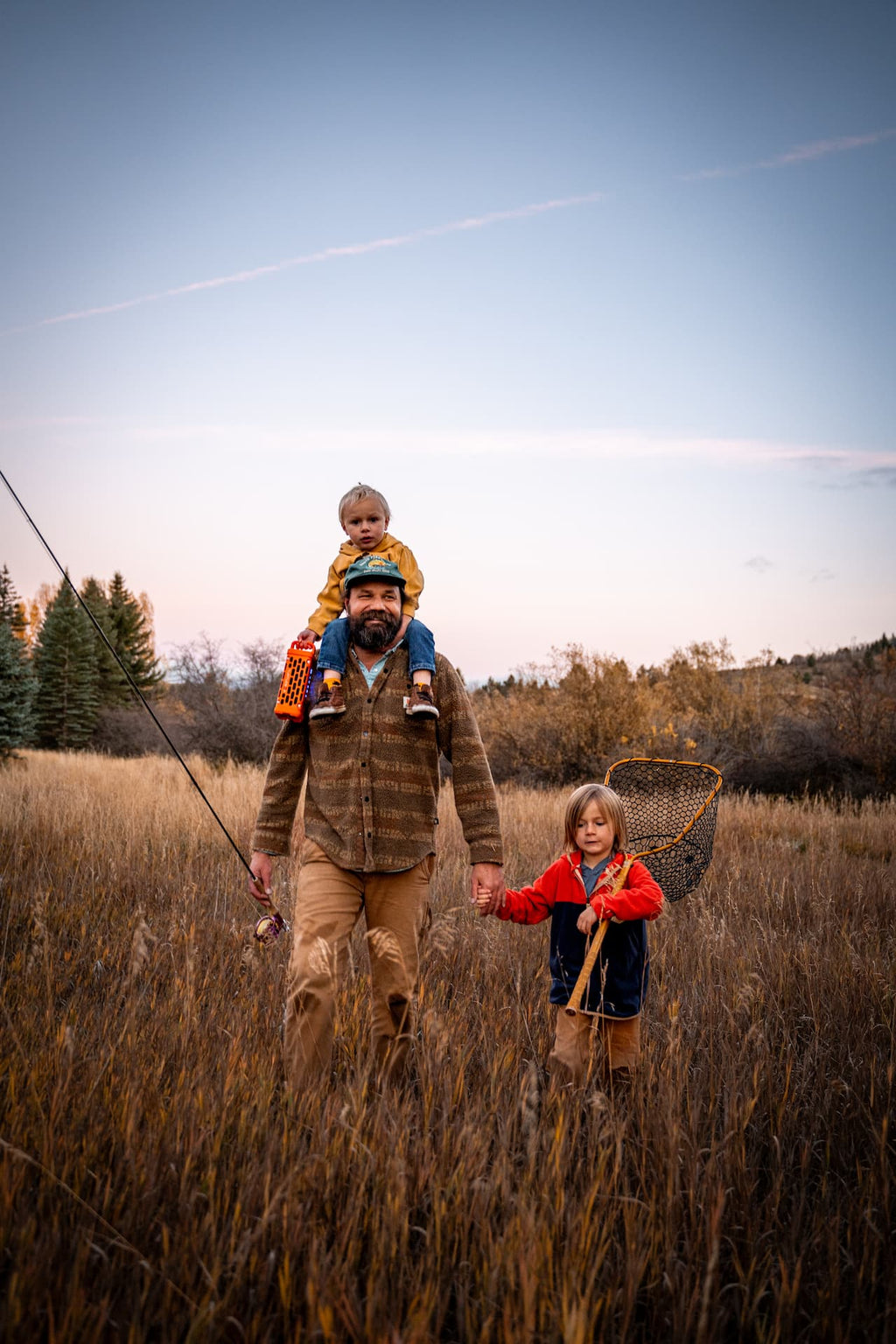 A lifestyle photo of a family with kids hanging a Ranger speaker in orange and a fishing net #base-color_orange