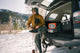 A lifestyle photo of a guy changing boots with Original Gen 3 orange speaker. #speaker-color_orange