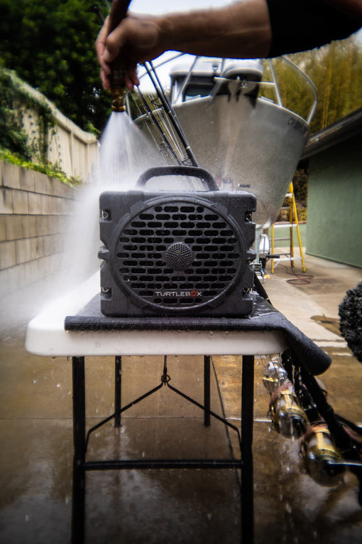 A lifestyle photo of a man washing his Turtlebox Grande speaker in gray color #speaker-color_gray